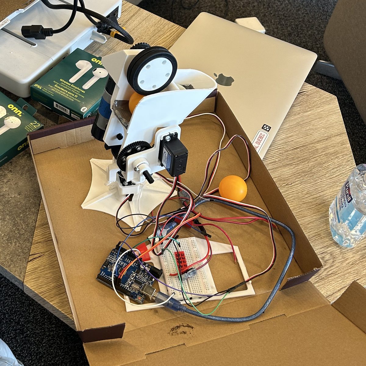The RythmHacks turret: a 3D-printed ping-pong ball launcher with a flywheel and servos, wired to an Arduino